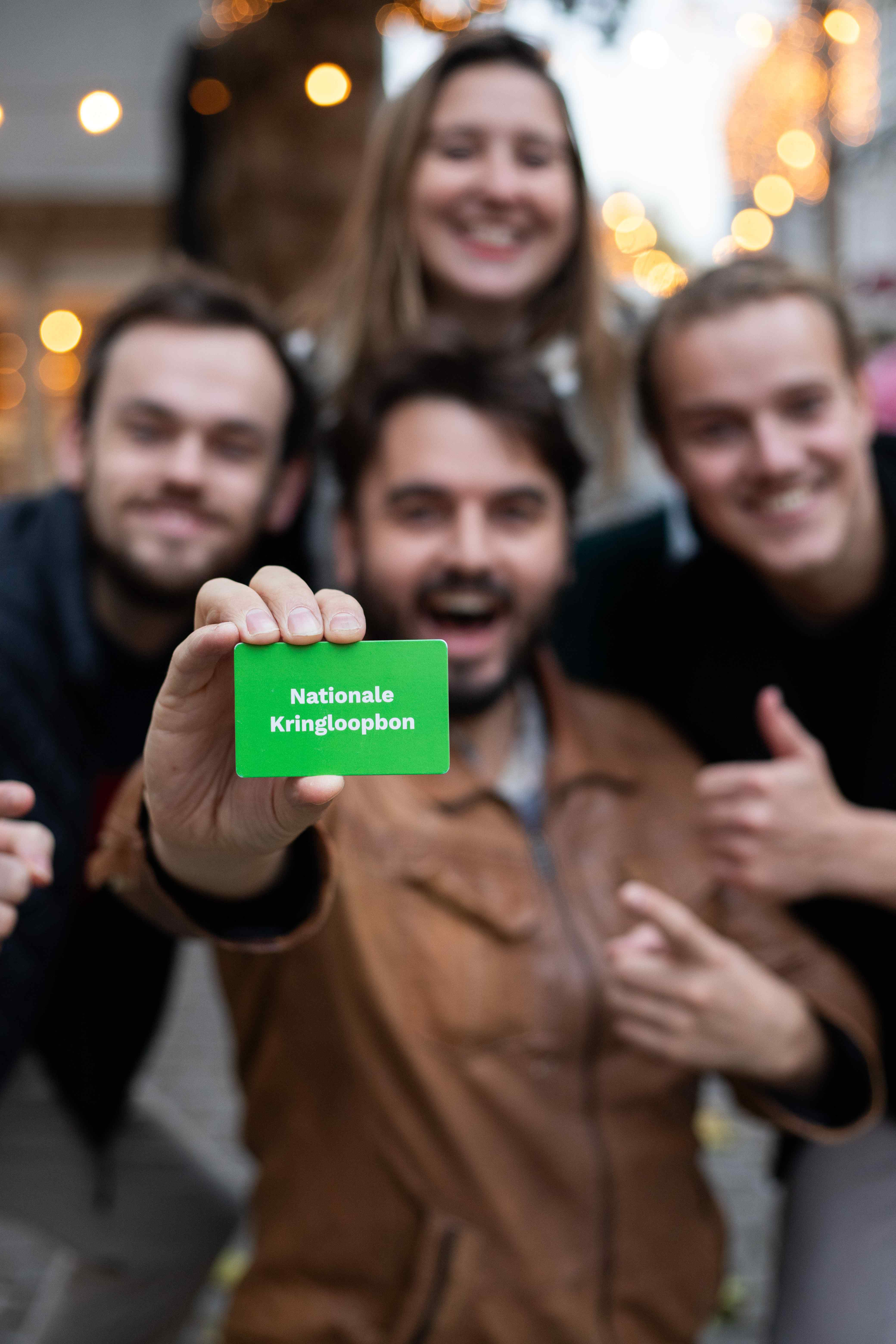 Vier enthousiaste mensen met een Nationale Kringloopbon